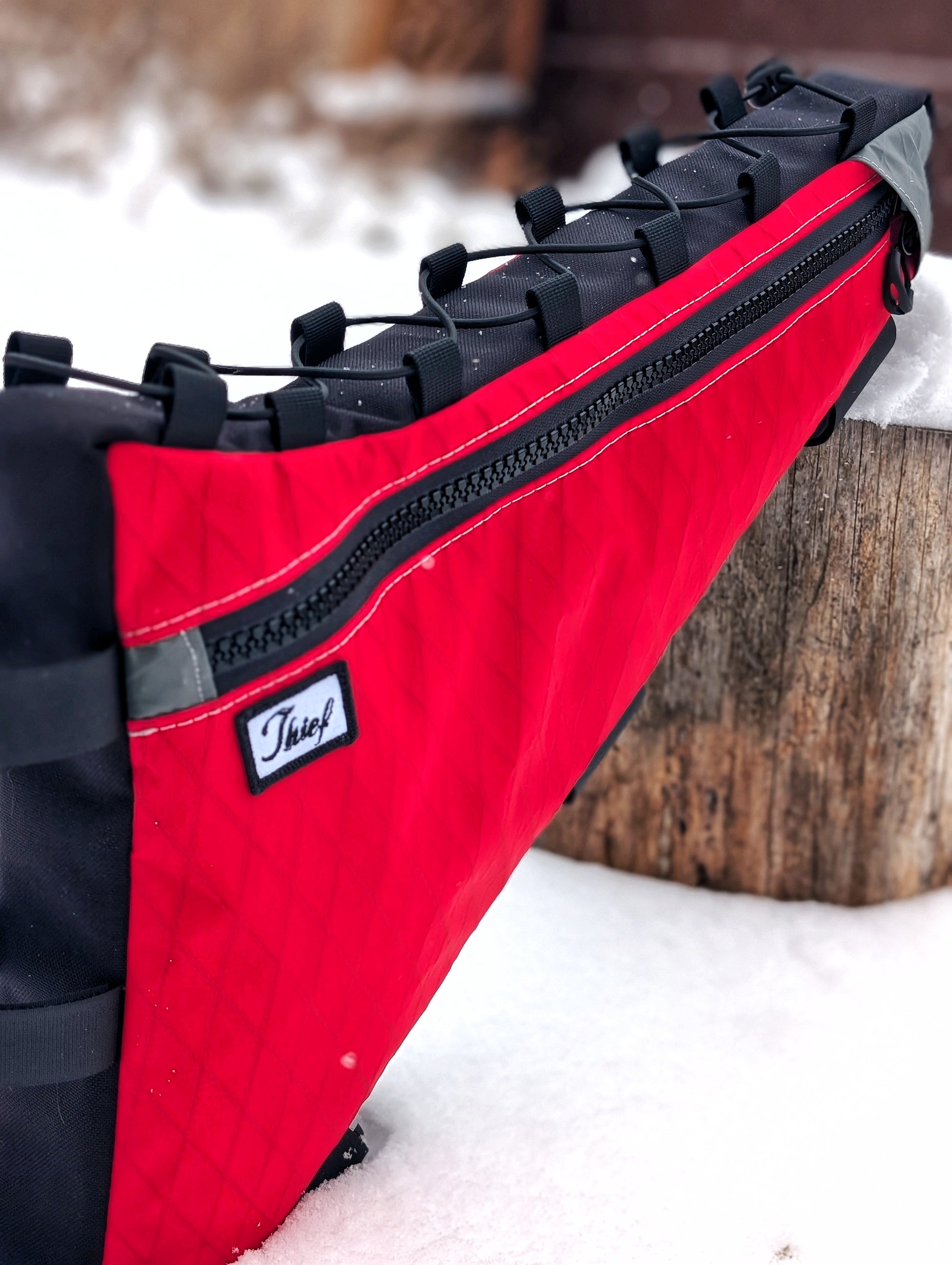 Red and black bag with a visible brand logo on a snowy background